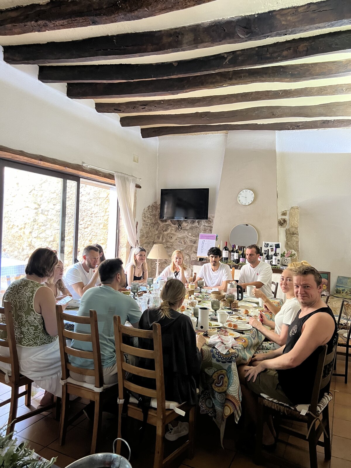 Alumnos y equipo comiendo juntos en una casa con vigas de madera