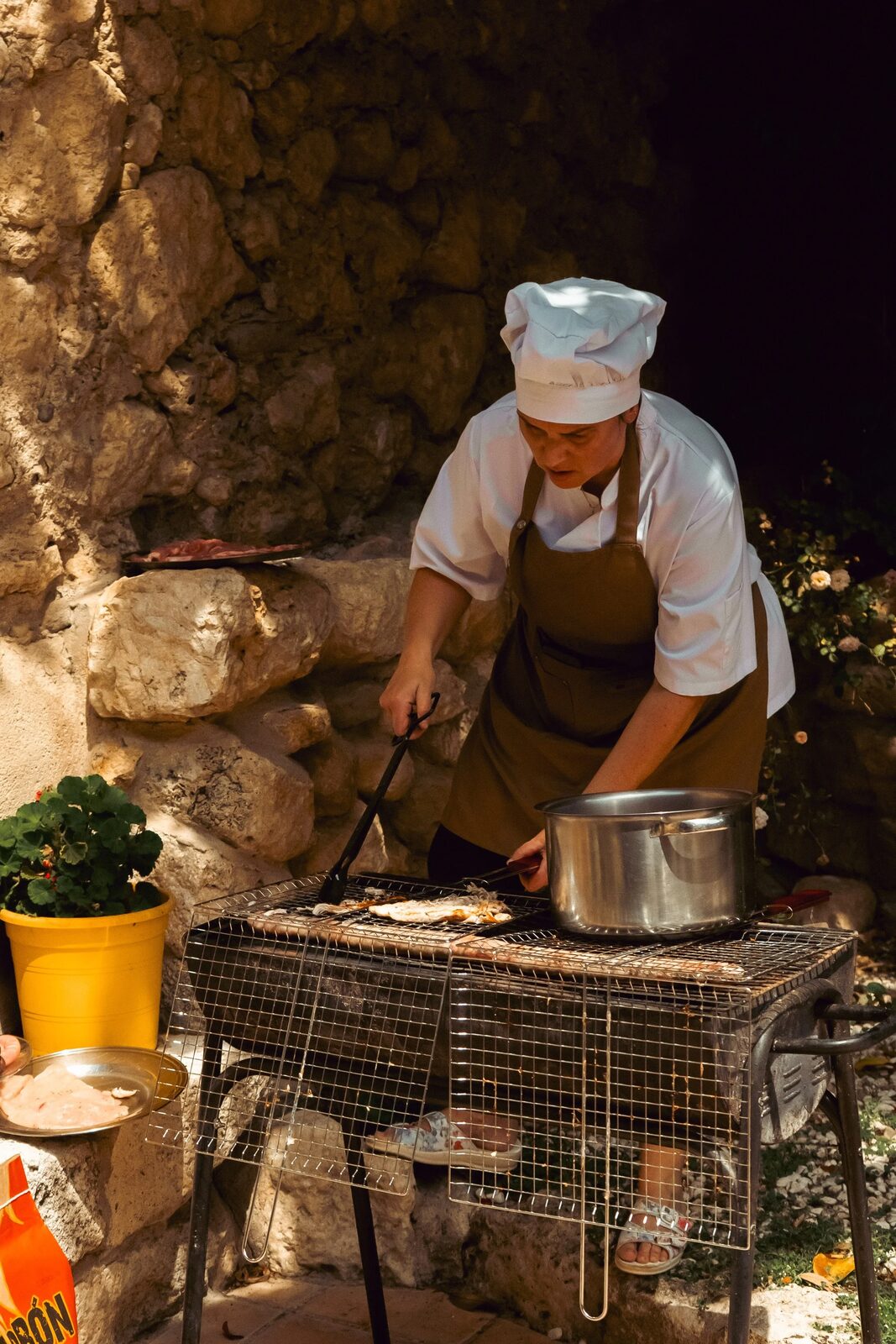 La cocinera preparando la cena al fuego